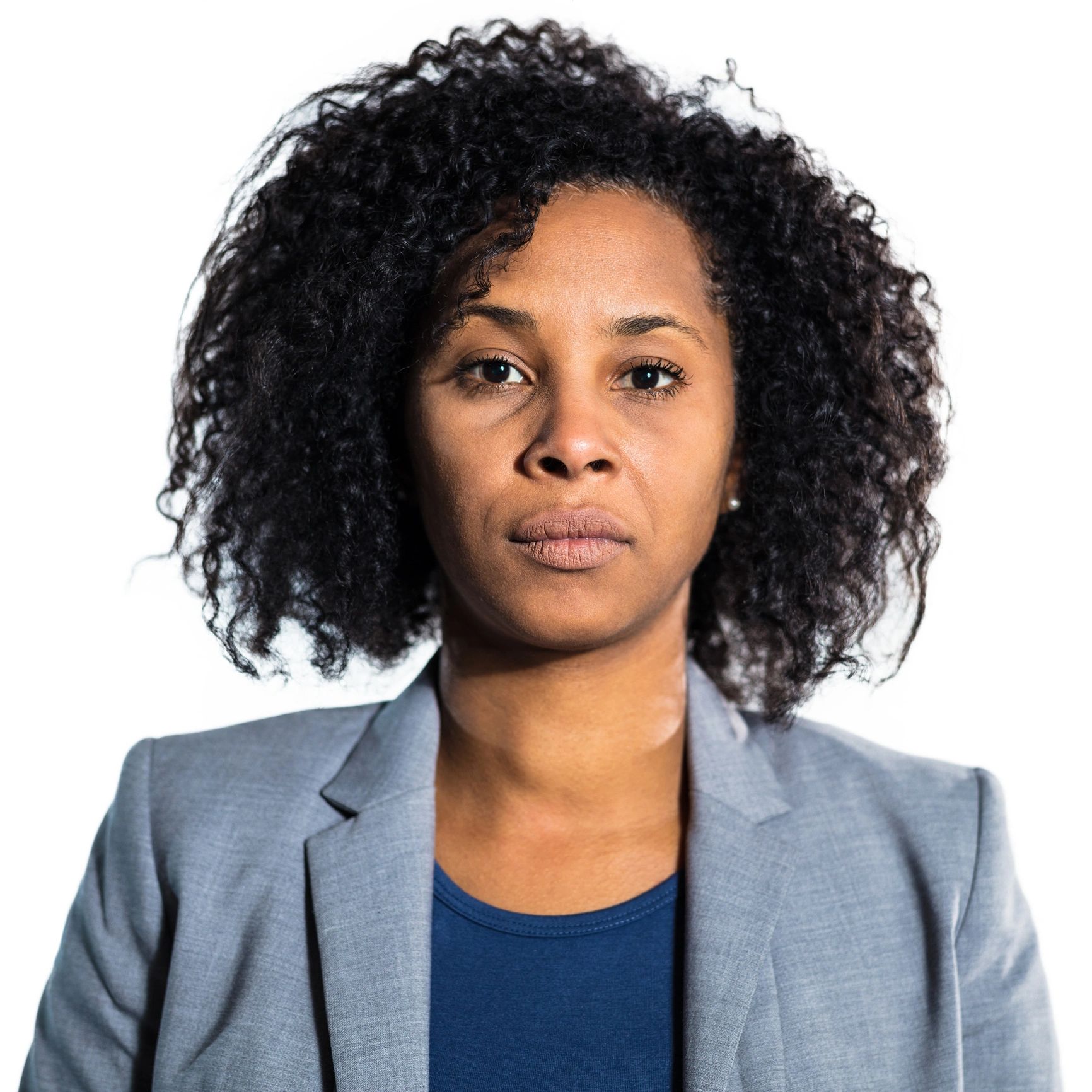 Professional headshot of a woman with short afro hair on a white background
