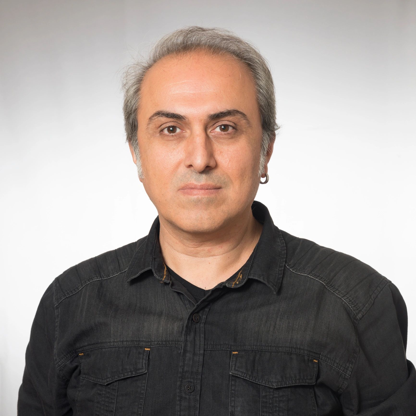 Professional headshot of a smiling man on a neutral background
